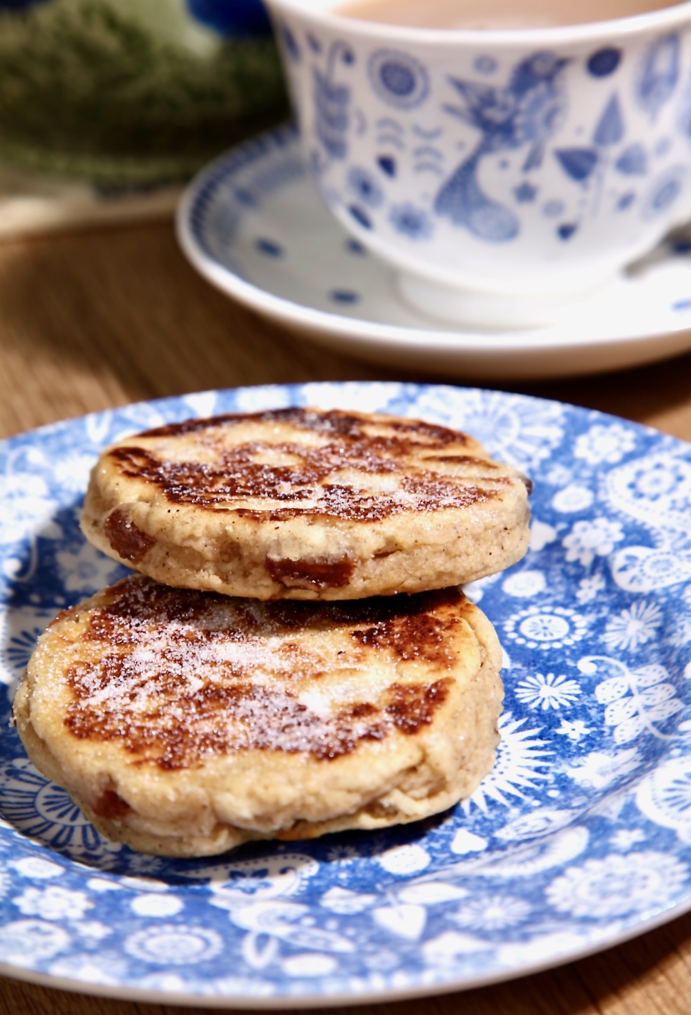 Two egg and dairy free Welsh cakes on a blue patterned plate.