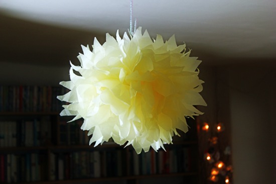 Tissue paper pom pom hanging from a pipe cleaner.