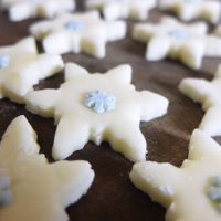 White peppermint creams cut in snowflake shapes and topped with mini blue icing snowflakes.