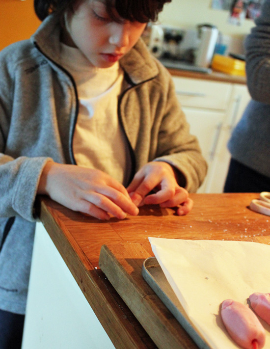 Young boy shaping a sugar mouse by hand.