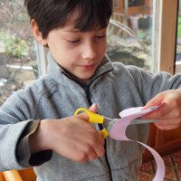 Young boy working on a paper rose.