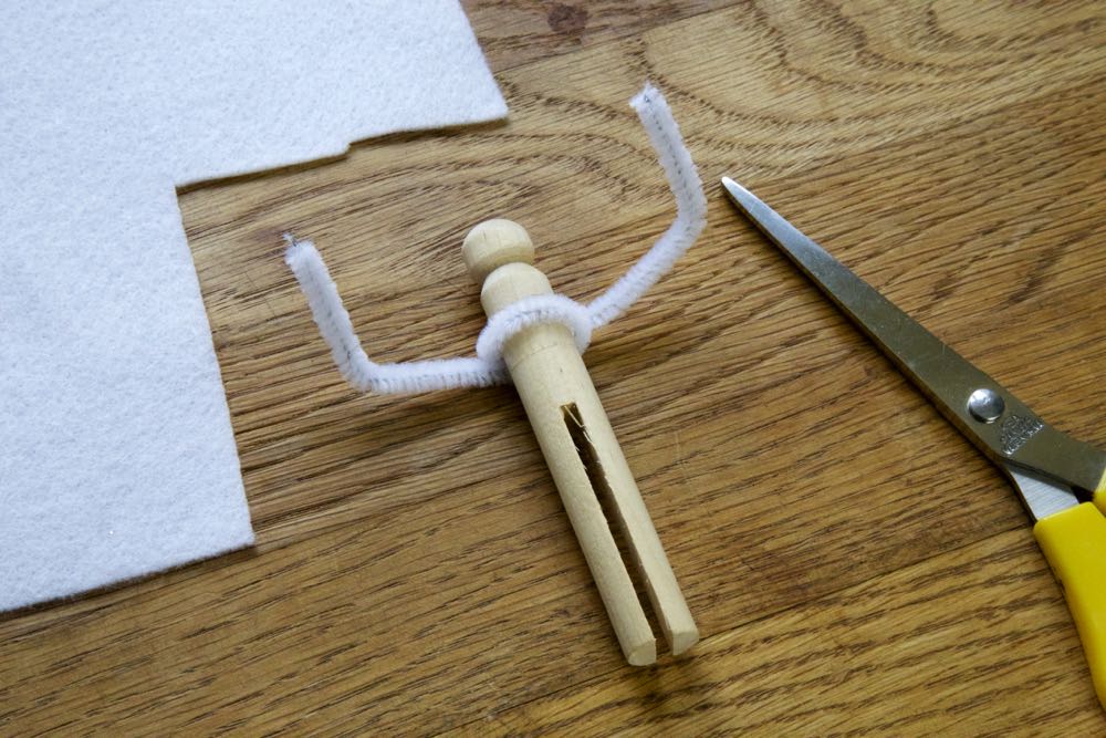 Clothes peg with pipe cleaner arms.