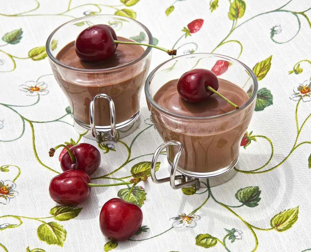 Vegan chocolate mousse with cherries, served in small glasses.