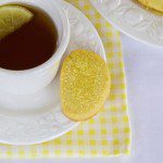 Lemon shortbread served on the saucer of a cup of earl grey tea.
