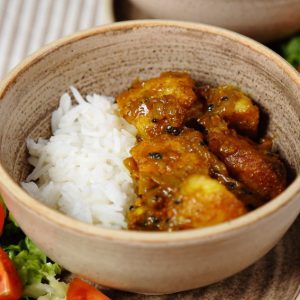 Roast Potato Curry Served with Basmati Rice in a rustic bowl