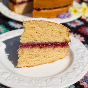 A slice of vegan sponge cake, filled with raspberry jam