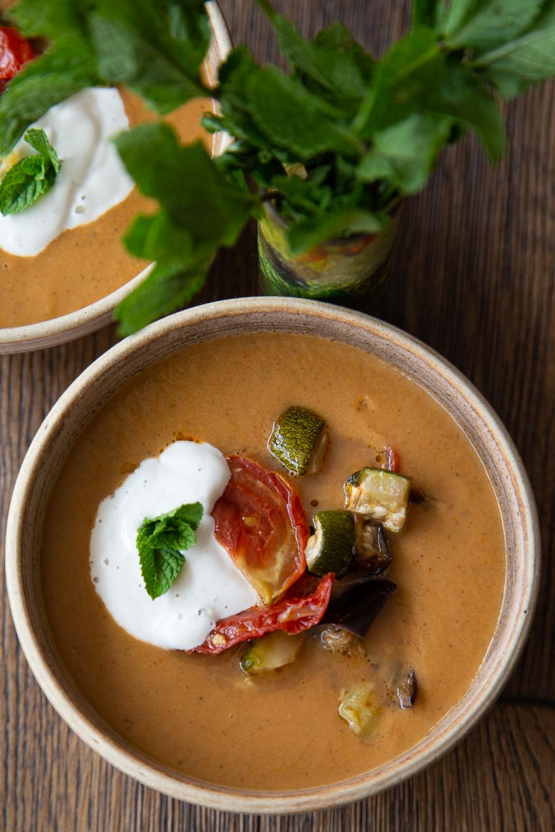 A bowl of Mediterranean vegetable soup topped with yoghurt and mint.