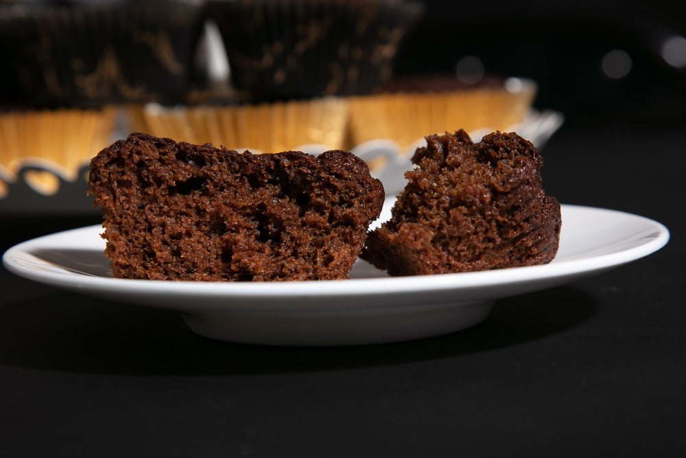 A gingerbread muffin split in half to show the fluffy interior.