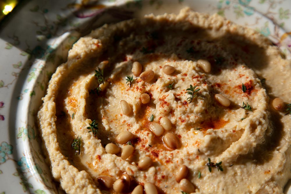 Hummus topped with pine nuts, thyme and paprika.