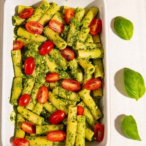 Easy Pesto pasta Bake topped with tomatoes, ready for the oven.