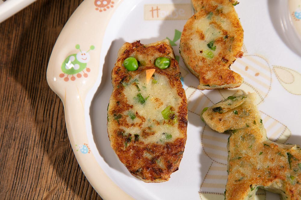 Owl shaped potato cake with peas for eyes.