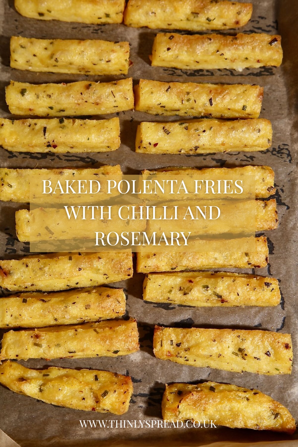 A pinterest friendly image of Polenta Fries lying on a baking tray. Text box says 'Baked Polenta Fries with Chilli and Rosemary,.